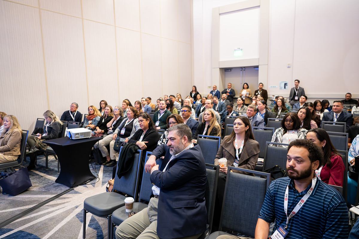 A packed audience listening during a session