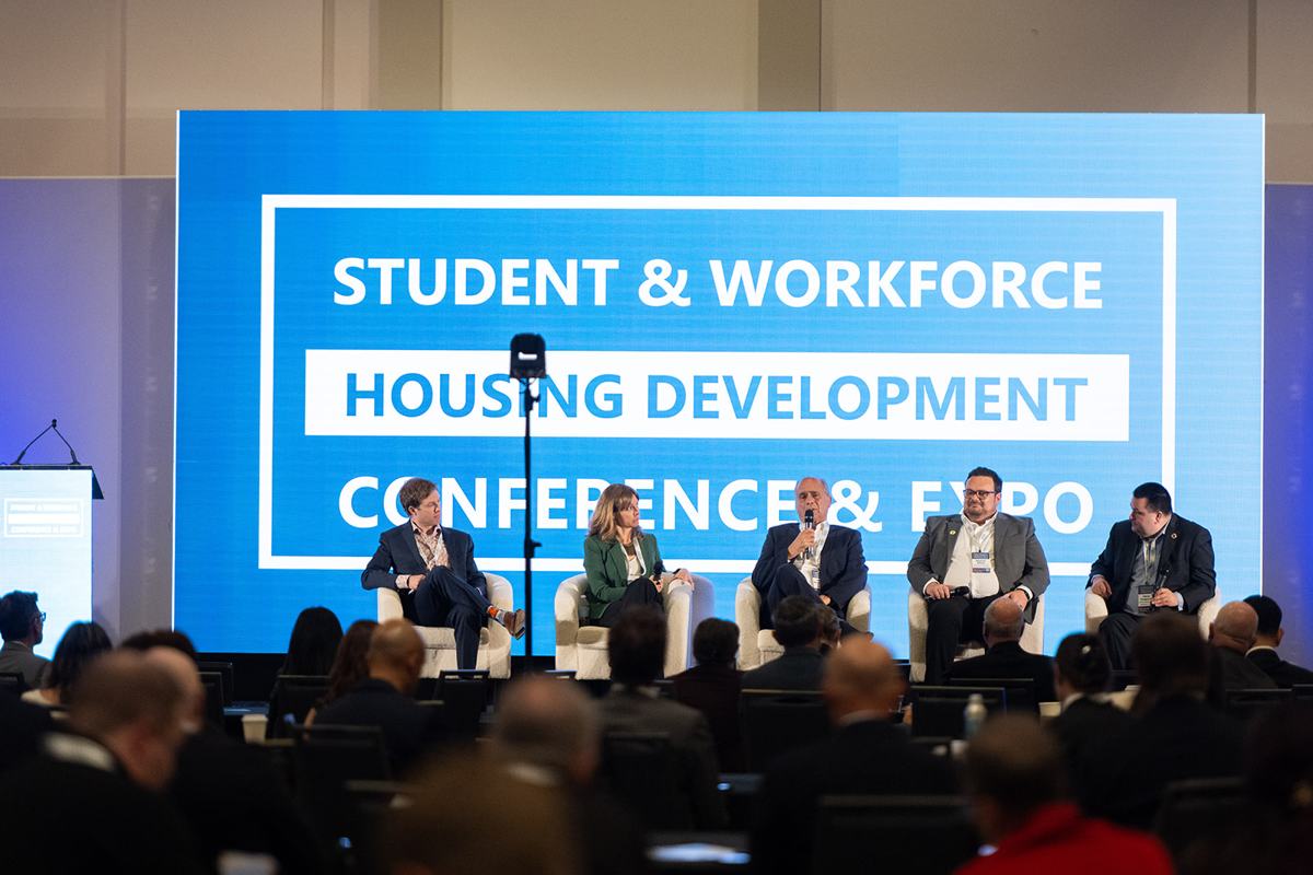 A panel on the main stage in front of a full audience at the 2025 Student & Workforce Housing Development Conference