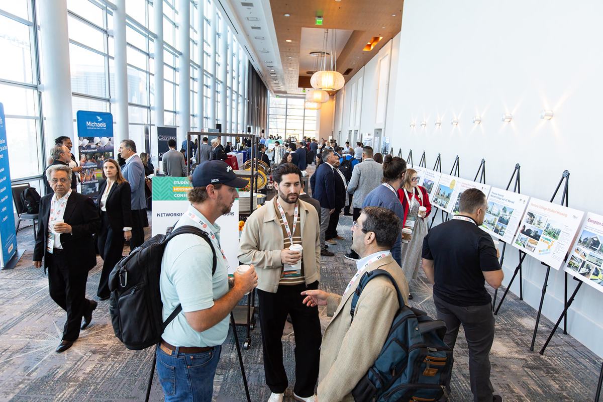 Attendees in a busy concourse with project boards on easels