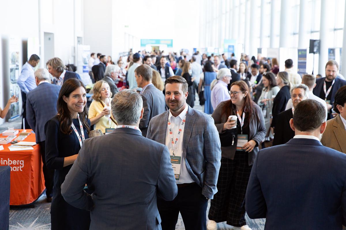 A crowded concourse of attendees networking between sessions