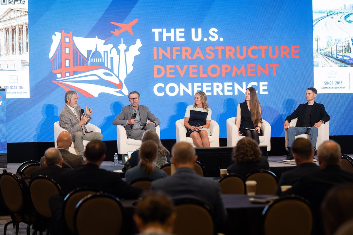 A panel on stage in front of a full audience