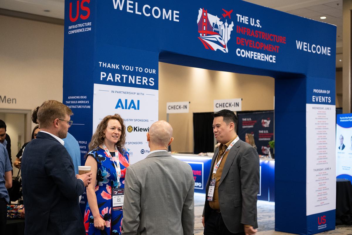 Attendees beneath the conference welcome arch